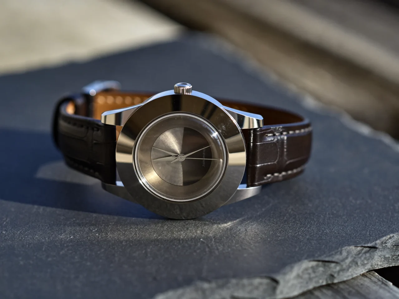 Klassische mechanische Armbanduhr mit Stahlgehäuse und Lederarmband auf Schieferfläche